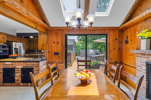 171 Still Rd, West Hartford, CT 06117 - dining area with vaulted ceiling, a chandelier, a skylight, and wood walls