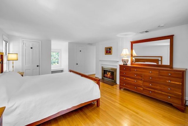 171 Still Rd, West Hartford, CT 06117 - bedroom featuring light wood finished floors and a fireplace with flush hearth