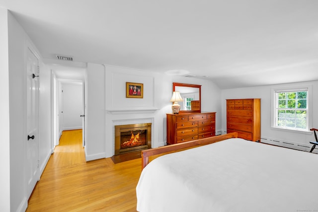 171 Still Rd, West Hartford, CT 06117 - bedroom featuring baseboard heating, light wood finished floors, a glass covered fireplace, and lofted ceiling