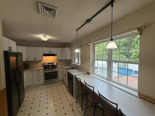 24 Podunk Cir Unit 24, South Windsor, CT 06074 - kitchen featuring black appliances, light countertops, a textured ceiling, ventilation hood, and white cabinetry