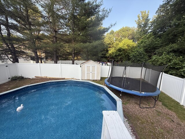 24 Podunk Cir Unit 24, South Windsor, CT 06074 - view of swimming pool featuring a trampoline, a storage unit, and a fenced backyard