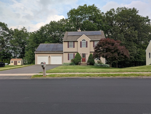 190 Sunnydale Ave, Bristol, CT 06010 - view of front of home featuring solar panels, an attached garage, driveway, a front lawn, and view of wooded area