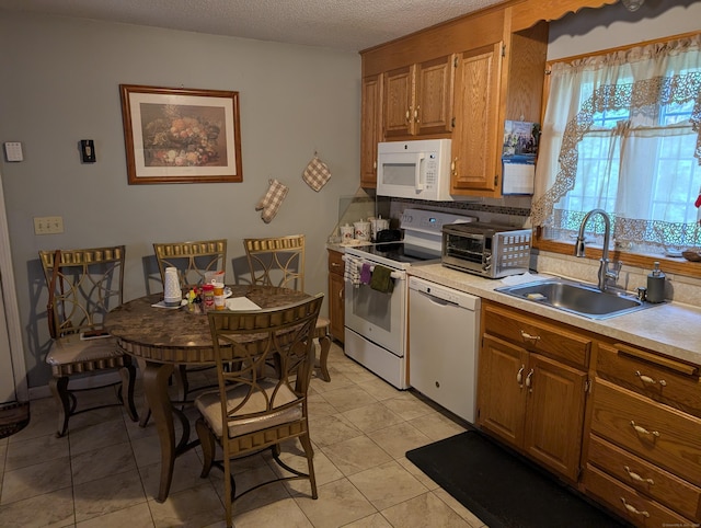 190 Sunnydale Ave, Bristol, CT 06010 - kitchen featuring white appliances, a sink, light countertops, and brown cabinets