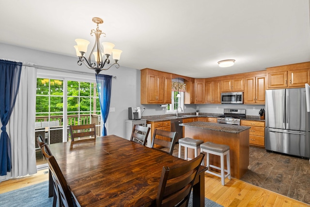 43 Old Young St, East Hampton, CT 06424 - kitchen with stainless steel appliances, a chandelier, dark countertops, a center island, and wood finished floors