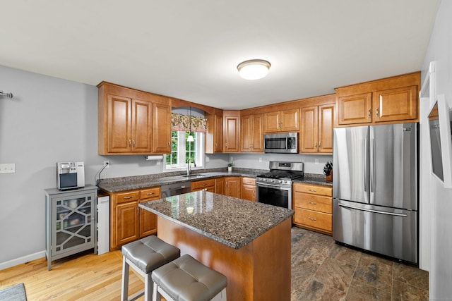 43 Old Young St, East Hampton, CT 06424 - kitchen featuring stainless steel appliances, a kitchen bar, brown cabinets, and a kitchen island
