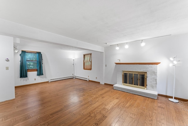 120 Pulaski Hwy, Ansonia, CT 06401 - unfurnished living room featuring wood-type flooring, a baseboard radiator, a brick fireplace, and track lighting