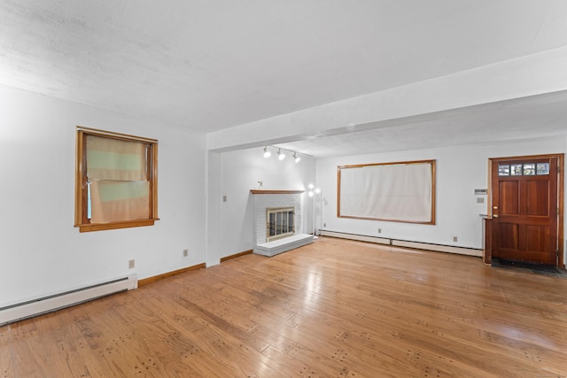 120 Pulaski Hwy, Ansonia, CT 06401 - unfurnished living room with a baseboard heating unit, baseboard heating, a brick fireplace, hardwood / wood-style floors, and rail lighting