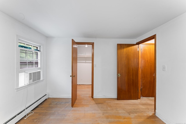120 Pulaski Hwy, Ansonia, CT 06401 - unfurnished bedroom featuring a baseboard radiator, light wood finished floors, a walk in closet, a closet, and cooling unit