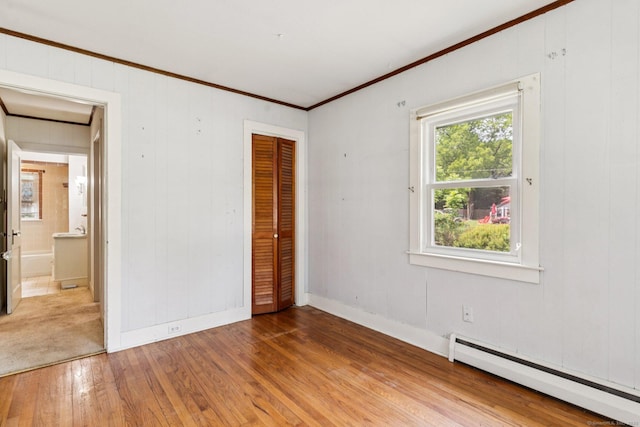 44 Nod Rd, Clinton, CT 06413 - unfurnished bedroom featuring baseboard heating, hardwood / wood-style flooring, ornamental molding, a closet, and baseboards