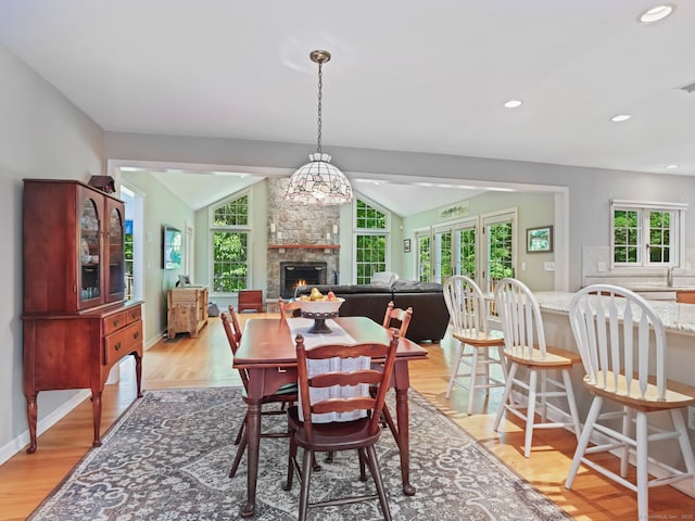 52 Grumman Ave, Wilton, CT 06897 - dining space featuring vaulted ceiling, healthy amount of natural light, a stone fireplace, recessed lighting, and light wood-style floors