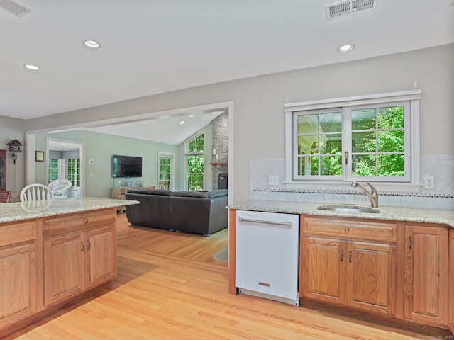 52 Grumman Ave, Wilton, CT 06897 - kitchen featuring white dishwasher, a stone fireplace, light wood-style floors, backsplash, and lofted ceiling