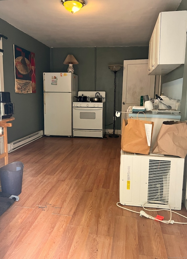 238 E Main St, Torrington, CT 06790 - kitchen with white appliances, a baseboard heating unit, wood finished floors, and white cabinetry