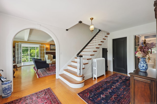 2200 Ridge Rd, North Haven, CT 06473 - foyer entrance featuring arched walkways, radiator heating unit, stairway, wood finished floors, and ornamental molding