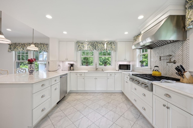2200 Ridge Rd, North Haven, CT 06473 - kitchen with wall chimney exhaust hood, stainless steel appliances, a peninsula, backsplash, and white cabinets