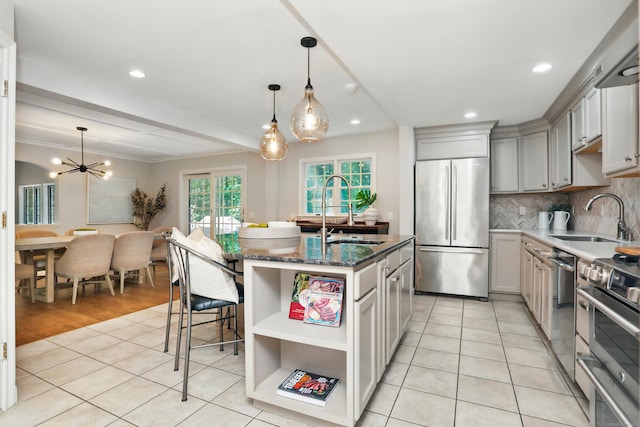 158 Linden Tree Rd, Wilton, CT 06897 - kitchen featuring appliances with stainless steel finishes, backsplash, light tile patterned floors, an island with sink, and dark stone countertops