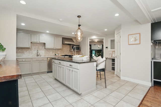 158 Linden Tree Rd, Wilton, CT 06897 - kitchen with wall chimney exhaust hood, a breakfast bar area, backsplash, a center island, and pendant lighting