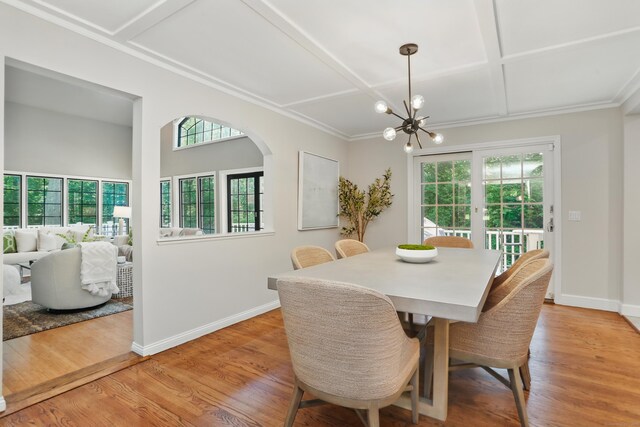 158 Linden Tree Rd, Wilton, CT 06897 - dining space with light wood finished floors, a chandelier, coffered ceiling, arched walkways, and french doors