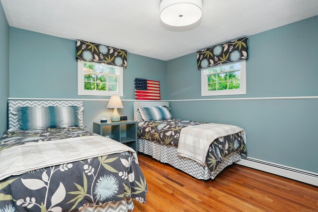 158 Linden Tree Rd, Wilton, CT 06897 - bedroom with multiple windows, baseboard heating, and wood finished floors