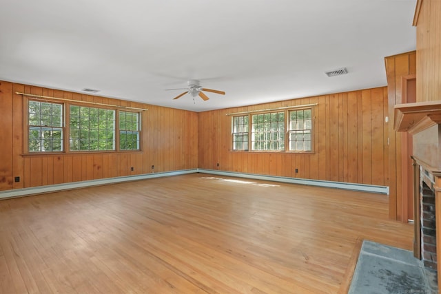 130 Sturbridge Ln, Fairfield, CT 06890 - unfurnished living room featuring light wood finished floors, ceiling fan, healthy amount of natural light, a fireplace, and wooden walls