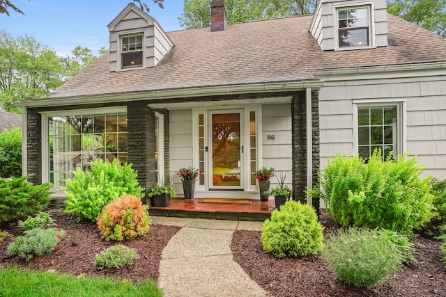 86 Lorma Ave, Trumbull, CT 06611 - view of exterior entry featuring a shingled roof, a chimney, and a porch