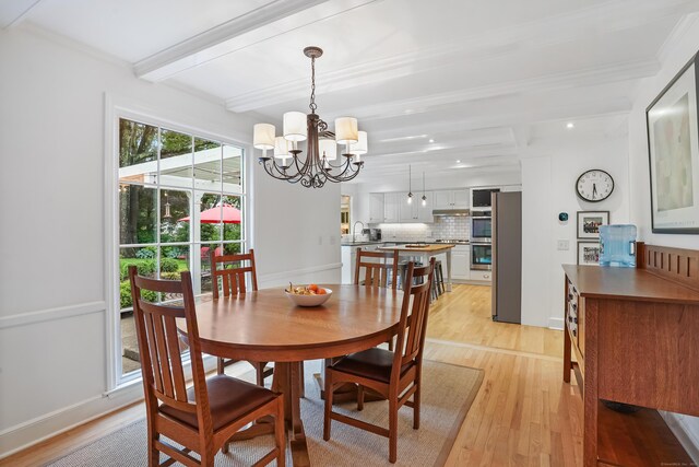 86 Lorma Ave, Trumbull, CT 06611 - dining space with beamed ceiling, light wood finished floors, a chandelier, and crown molding