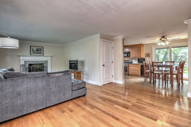 51 Crestwood Rd, Milford, CT 06460 - living room featuring light wood-style flooring, a fireplace, a ceiling fan, baseboards, and crown molding