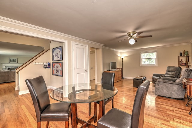 51 Crestwood Rd, Milford, CT 06460 - dining space with light wood-style floors, ceiling fan, crown molding, baseboards, and a fireplace