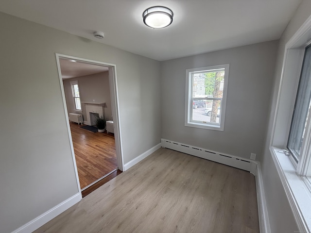 28 Highland Ave, Naugatuck, CT 06770 - unfurnished room with light wood finished floors, healthy amount of natural light, a smoke detector, and radiator heating unit