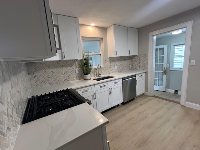 28 Highland Ave, Naugatuck, CT 06770 - kitchen featuring stainless steel dishwasher, decorative backsplash, light wood-style floors, light stone countertops, and white cabinetry
