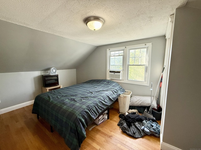 451 Robbins Ave, Newington, CT 06111 - bedroom featuring wood finished floors, baseboards, vaulted ceiling, a textured ceiling, and cooling unit