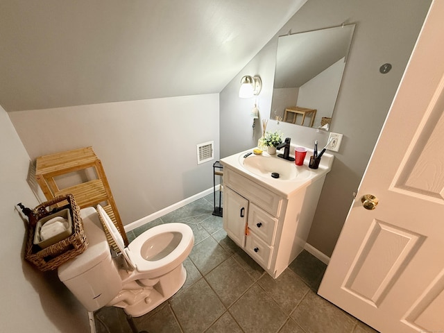 451 Robbins Ave, Newington, CT 06111 - bathroom featuring toilet, vanity, vaulted ceiling, baseboards, and tile patterned flooring