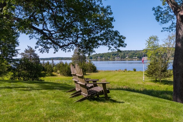 view of green lawn with a water view