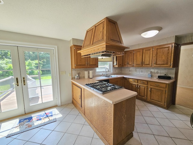 105 Minortown Rd, Woodbury, CT 06798 - kitchen with stainless steel gas cooktop, light countertops, a peninsula, light tile patterned floors, and french doors