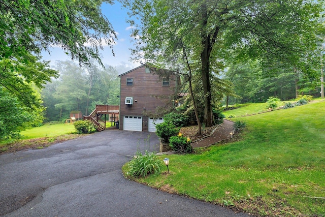 136 Wheeler Rd, Monroe, CT 06468 - view of side of home with stairway, asphalt driveway, a lawn, a garage, and a deck