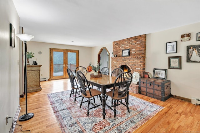 136 Wheeler Rd, Monroe, CT 06468 - dining room with baseboard heating, wood finished floors, french doors, and a brick fireplace