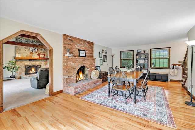 136 Wheeler Rd, Monroe, CT 06468 - dining room featuring a fireplace, wood finished floors, and stairs