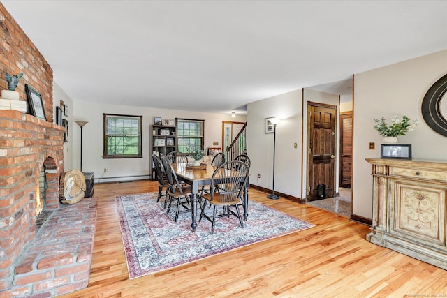 136 Wheeler Rd, Monroe, CT 06468 - dining room with a baseboard heating unit, wood finished floors, a fireplace, and stairs