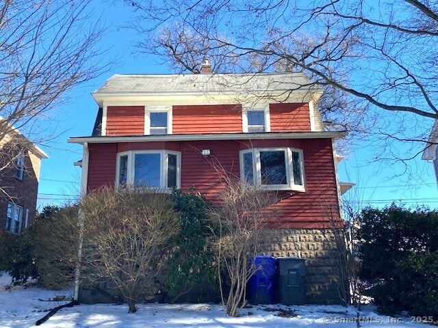 242 Pearl St, Enfield, CT 06082 - view of snowy exterior with a chimney