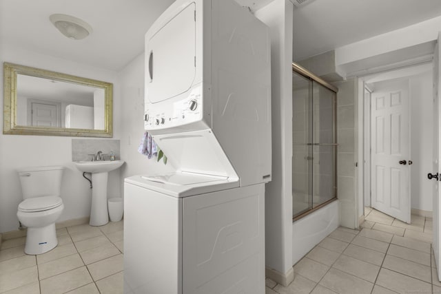 408 Stage Coach Rd, Durham, CT 06422 - bathroom with stacked washer / dryer, tile patterned floors, and bath / shower combo with glass door