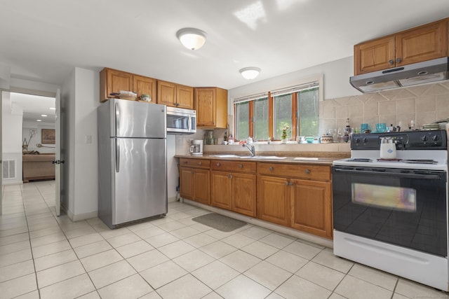 408 Stage Coach Rd, Durham, CT 06422 - kitchen featuring appliances with stainless steel finishes, under cabinet range hood, brown cabinetry, backsplash, and light tile patterned flooring