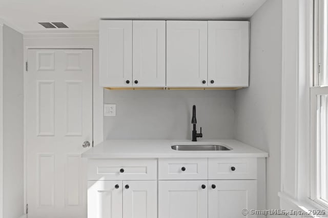 25 W Coit St, New London, CT 06320 - kitchen featuring a sink, light countertops, and white cabinetry