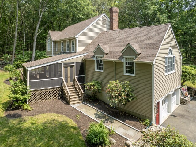 104 Scarlet Oak Dr, Wilton, CT 06897 - view of front of property with a sunroom, roof with shingles, a chimney, asphalt driveway, and a garage