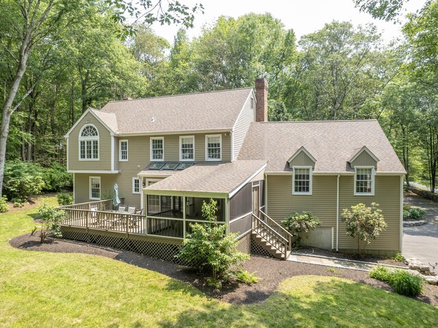 104 Scarlet Oak Dr, Wilton, CT 06897 - view of front of home with a sunroom, roof with shingles, a chimney, a front lawn, and a wooden deck
