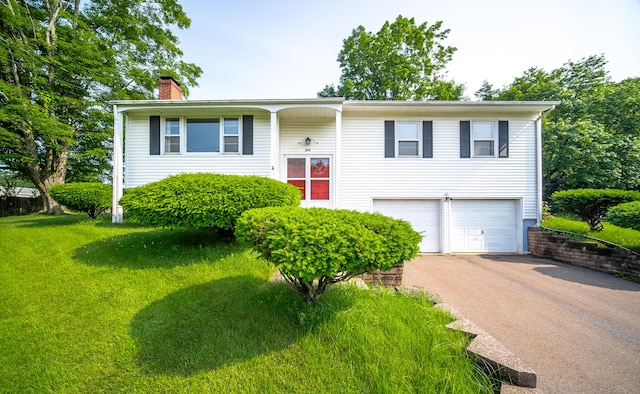 895 W Woods Rd, Hamden, CT 06518 - split foyer home featuring a chimney, an attached garage, driveway, and a front lawn