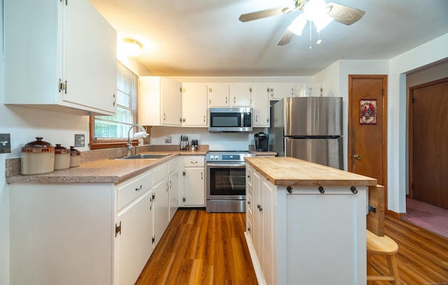 895 W Woods Rd, Hamden, CT 06518 - kitchen with appliances with stainless steel finishes, wood counters, dark wood-type flooring, white cabinetry, and a center island