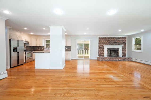 46 Columbine Dr, Trumbull, CT 06611 - unfurnished living room with plenty of natural light, crown molding, light wood-style floors, recessed lighting, and a sink