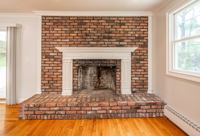 46 Columbine Dr, Trumbull, CT 06611 - detailed view of baseboard heating, wood finished floors, ornamental molding, a brick fireplace, and baseboards