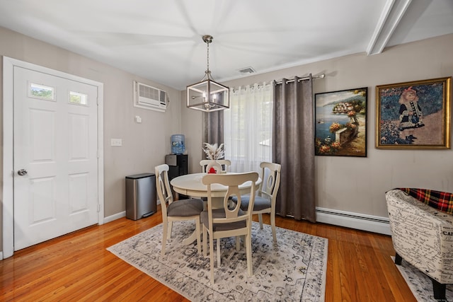 7 Pleasant St, Wolcott, CT 06716 - dining area featuring a baseboard radiator, a wall unit AC, light wood-style flooring, and a chandelier