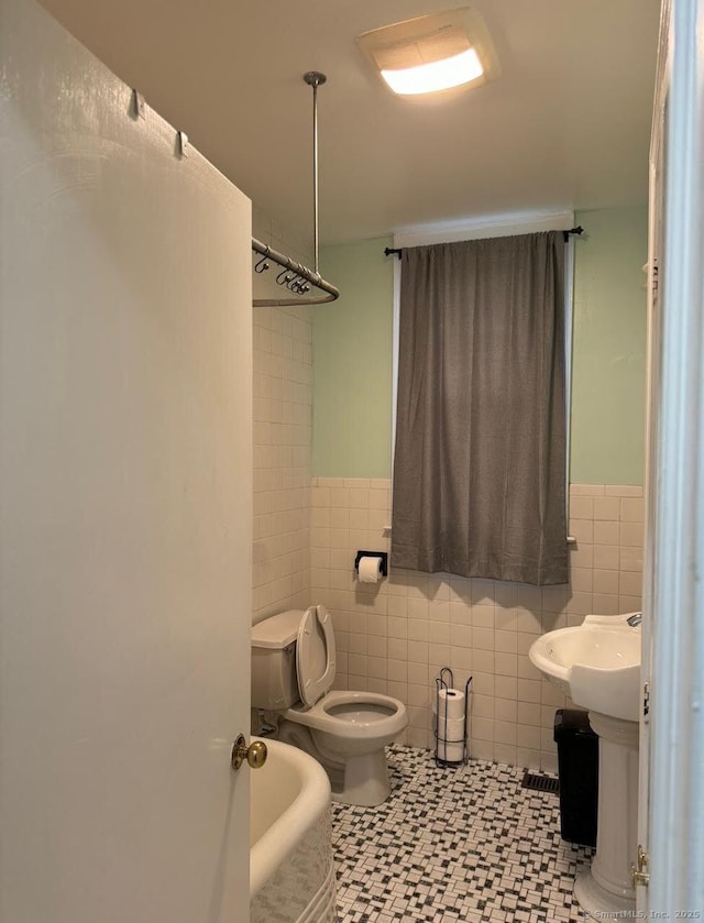 201 Center St, West Haven, CT 06516 - bathroom with tile walls, toilet, a bathtub, a wainscoted wall, and a sink