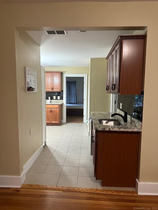 201 Center St, West Haven, CT 06516 - kitchen with a sink, tasteful backsplash, dark stone counters, baseboards, and light tile patterned floors
